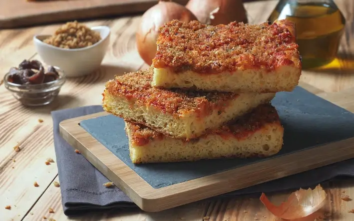 stacked pieces of pizza on a wooden board