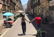 A couple walks hand in hand through Palermo's old town